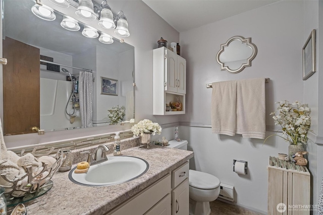 full bathroom featuring curtained shower, toilet, vanity, and baseboard heating