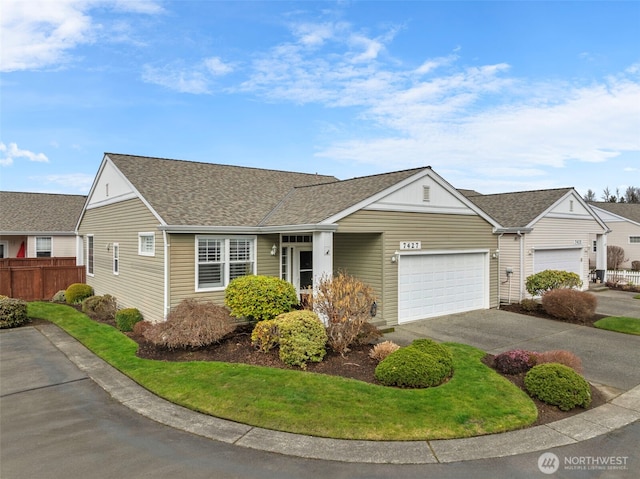 single story home featuring fence, a garage, driveway, and a shingled roof