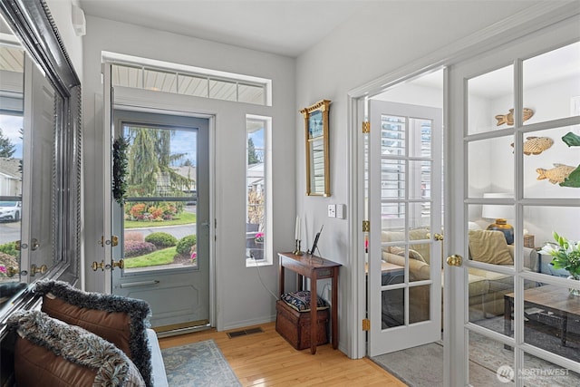 entryway with visible vents, light wood-style flooring, and french doors