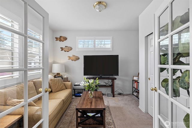 carpeted living area featuring french doors