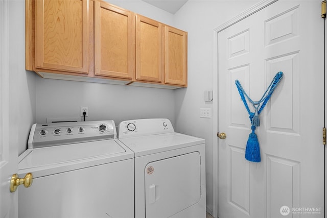 clothes washing area with washing machine and clothes dryer and cabinet space