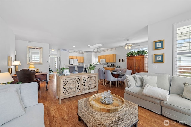 living area with light wood-type flooring and ceiling fan