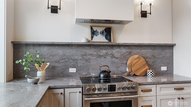 kitchen featuring stainless steel electric range oven, backsplash, white cabinets, and dark stone counters