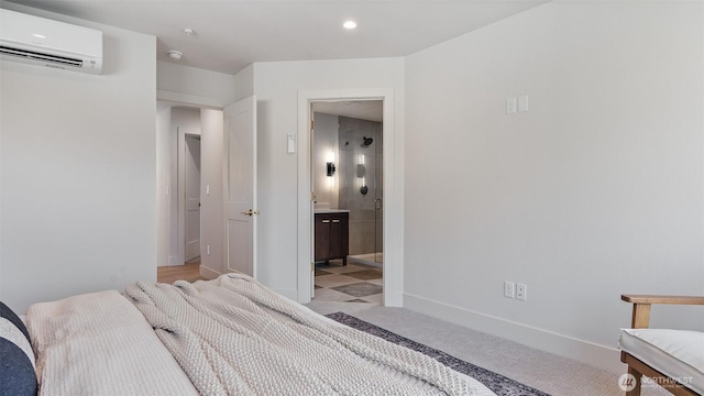 bedroom with baseboards, light colored carpet, a wall mounted air conditioner, recessed lighting, and ensuite bathroom