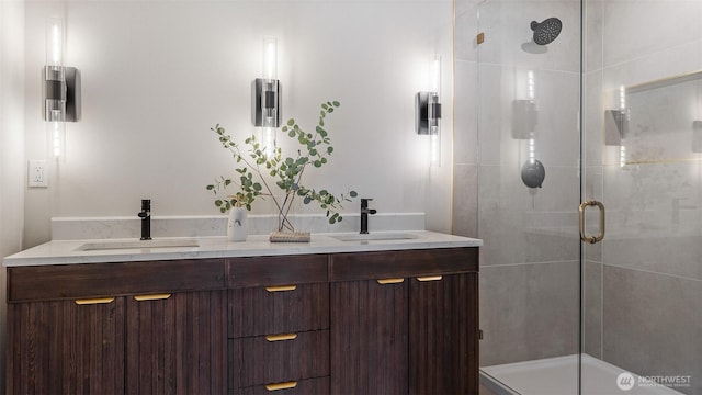 bathroom featuring double vanity, a shower stall, and a sink