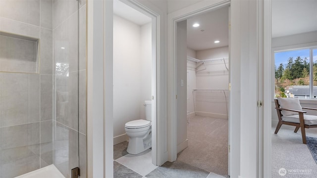 full bathroom with toilet, a stall shower, recessed lighting, baseboards, and a spacious closet