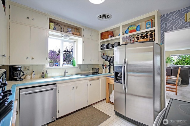 kitchen with white cabinets, visible vents, appliances with stainless steel finishes, a sink, and open shelves