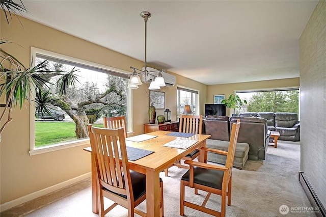 dining room with baseboards, a chandelier, and light carpet