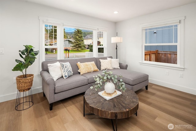 living room featuring light wood-style flooring, recessed lighting, and baseboards