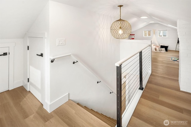 stairway with vaulted ceiling and wood finished floors