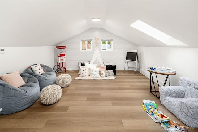 rec room featuring vaulted ceiling with skylight and wood finished floors