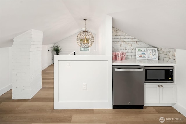 kitchen with vaulted ceiling, light wood-style floors, appliances with stainless steel finishes, and light countertops