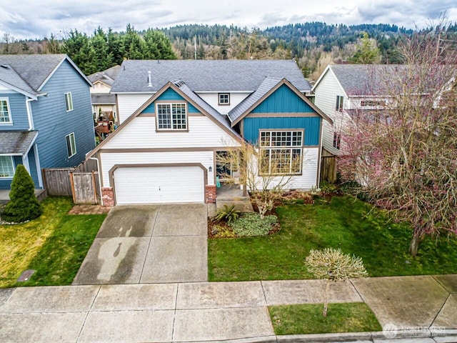 traditional home with a garage, concrete driveway, a front yard, and fence