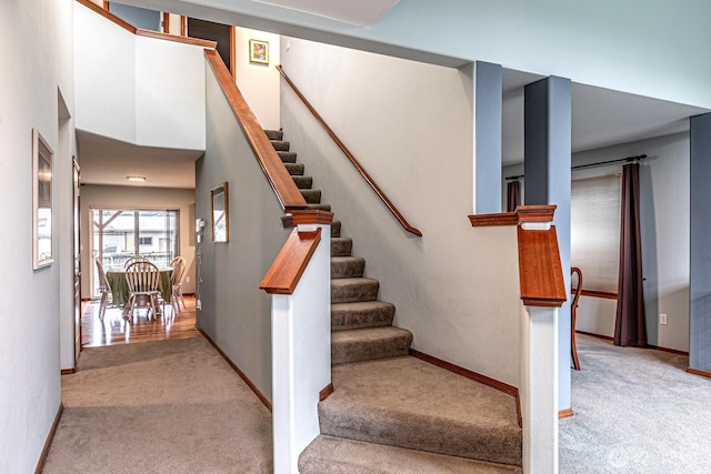 staircase featuring baseboards and carpet floors