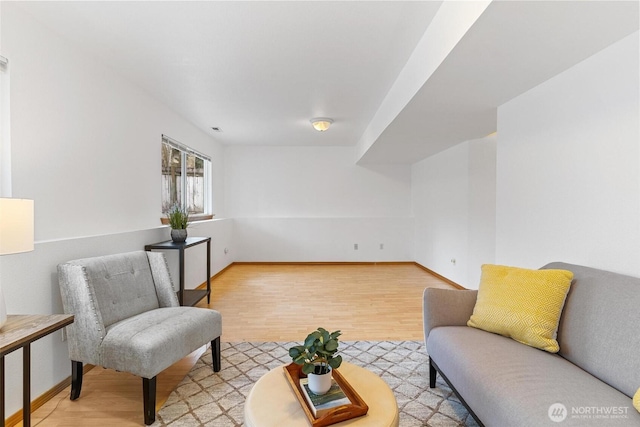 sitting room featuring baseboards and light wood finished floors