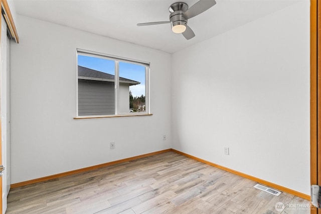 spare room with light wood-style flooring, baseboards, and visible vents