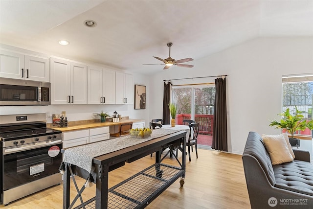 kitchen featuring plenty of natural light, appliances with stainless steel finishes, light wood-type flooring, and lofted ceiling