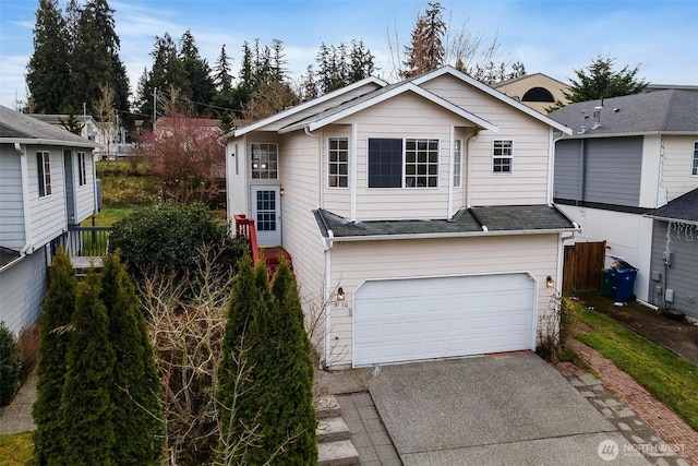 view of front of house with an attached garage, driveway, and fence