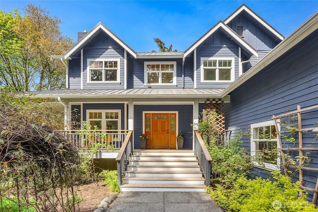 view of front of home with board and batten siding, a standing seam roof, metal roof, and covered porch