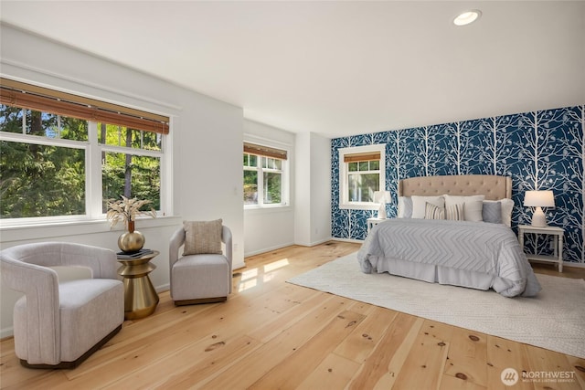 bedroom with wood-type flooring, an accent wall, baseboards, wallpapered walls, and recessed lighting