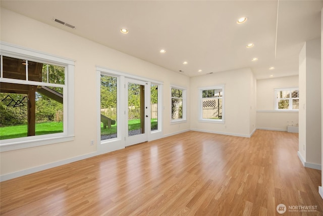 unfurnished living room with baseboards, light wood finished floors, recessed lighting, and visible vents
