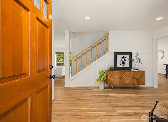 entryway with recessed lighting, light wood finished floors, and stairs