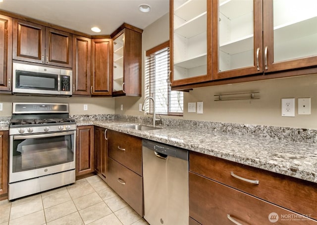 kitchen featuring light stone countertops, light tile patterned floors, recessed lighting, appliances with stainless steel finishes, and a sink