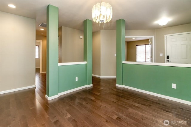 interior space with an inviting chandelier, wood finished floors, baseboards, and visible vents