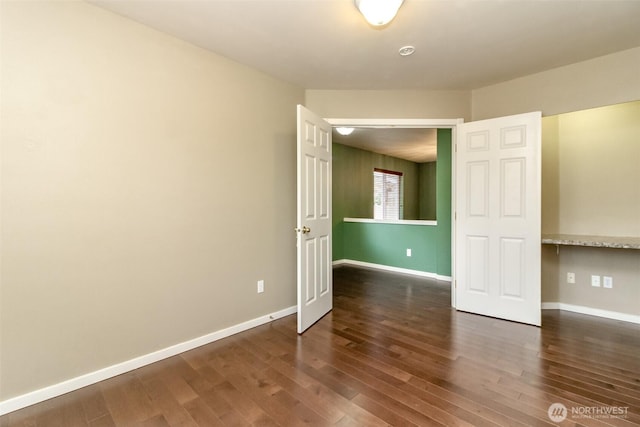 unfurnished room featuring baseboards and wood finished floors