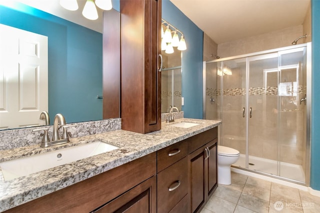 bathroom featuring a sink, a stall shower, and double vanity