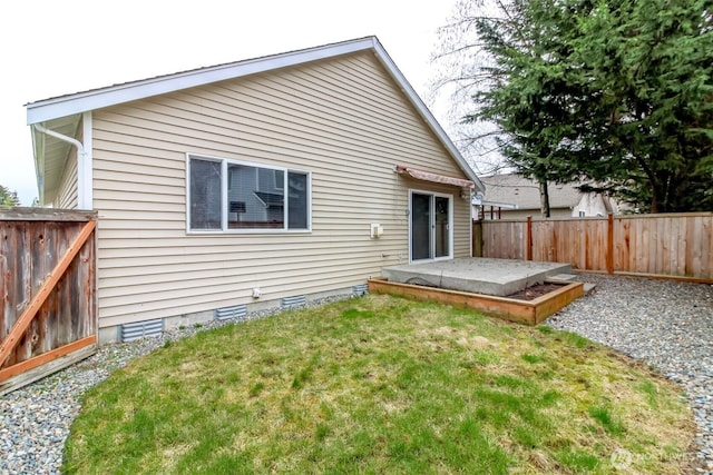 back of property with crawl space, a lawn, and a fenced backyard