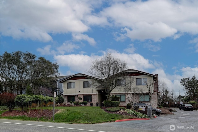 view of front of property with a front lawn and brick siding