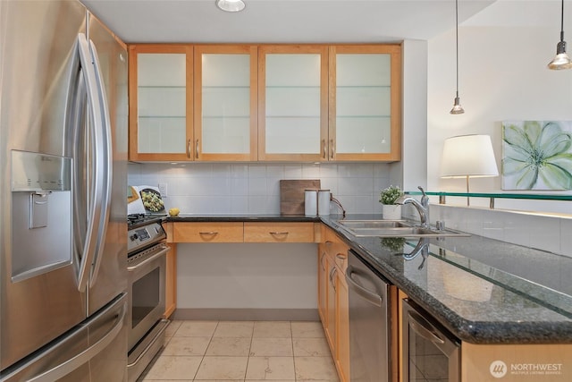 kitchen featuring backsplash, beverage cooler, dark stone counters, appliances with stainless steel finishes, and a sink