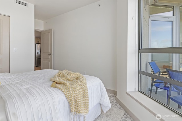 bedroom featuring stainless steel fridge with ice dispenser, visible vents, and baseboards