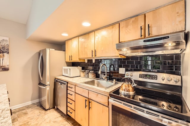 kitchen with tasteful backsplash, light brown cabinets, under cabinet range hood, stainless steel appliances, and a sink