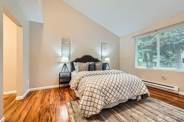 bedroom with baseboards, a baseboard heating unit, light wood-style floors, and vaulted ceiling