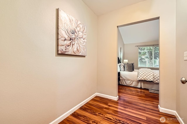 hall featuring baseboards and wood finished floors