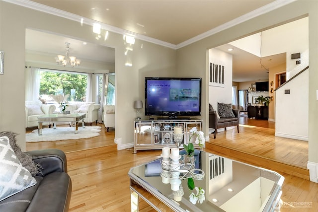 living area with baseboards, an inviting chandelier, crown molding, and hardwood / wood-style flooring