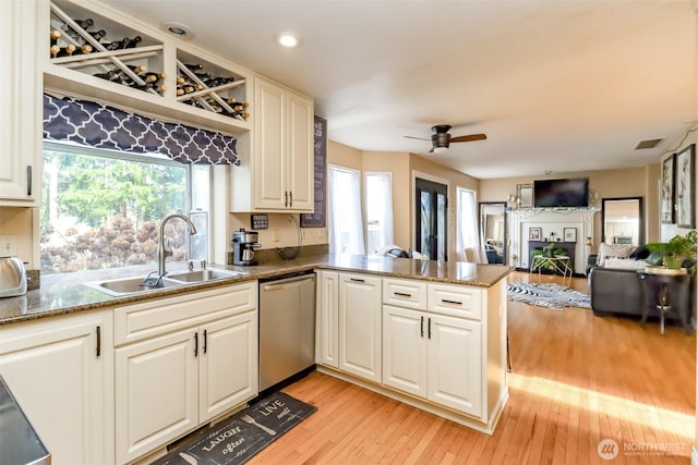 kitchen with visible vents, open floor plan, a peninsula, stainless steel dishwasher, and a sink