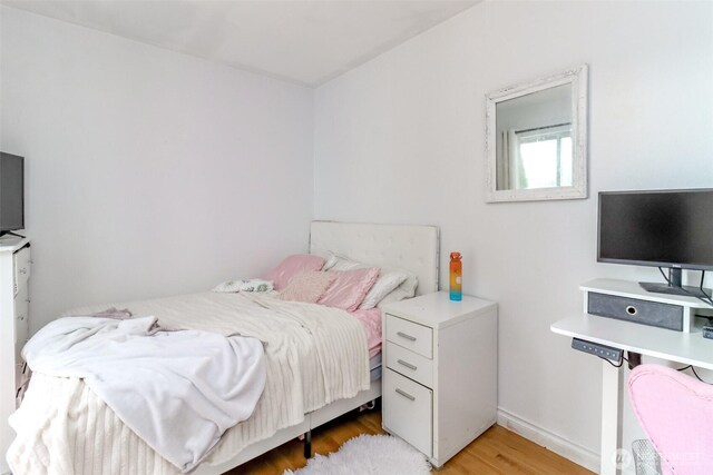 bedroom with baseboards and light wood-style floors