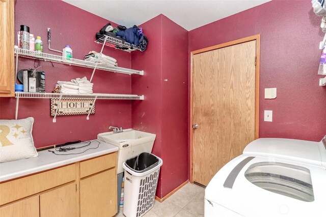 washroom featuring washer / dryer, light tile patterned floors, and cabinet space