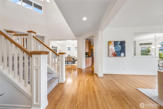 entryway with baseboards, a chandelier, stairway, light wood-type flooring, and recessed lighting