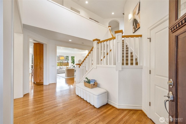 entrance foyer featuring recessed lighting, stairway, light wood-style flooring, and baseboards