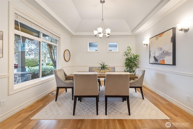 dining space with visible vents, baseboards, an inviting chandelier, and light wood-style flooring