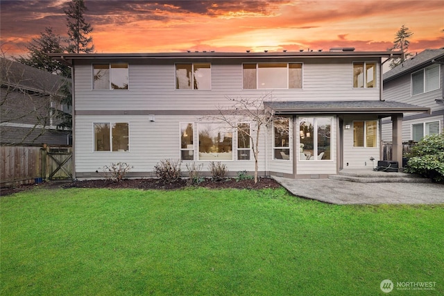 back of house at dusk with a patio area, crawl space, a yard, and fence