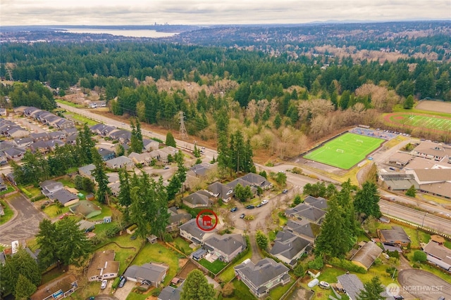 aerial view featuring a wooded view and a residential view