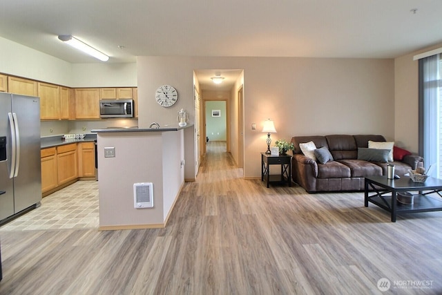 kitchen with visible vents, dark countertops, open floor plan, stainless steel appliances, and light wood-style floors