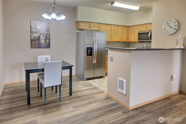 kitchen with light brown cabinets, visible vents, appliances with stainless steel finishes, and a chandelier