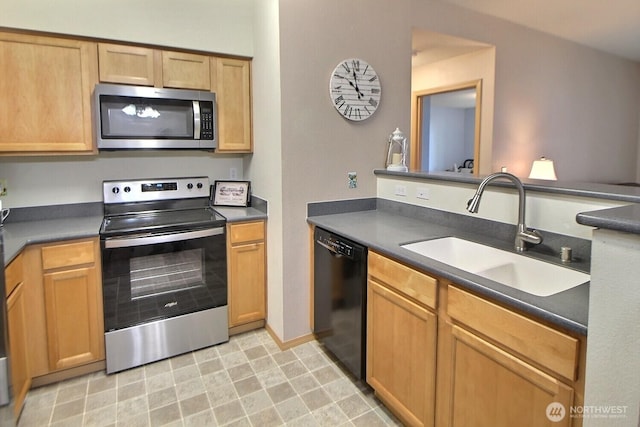 kitchen with a sink, dark countertops, and stainless steel appliances