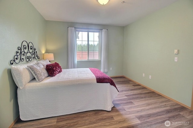 bedroom with wood finished floors and baseboards